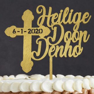 Close up van taarttopper met kruis, naam en datum voor doop, communie of vormsel